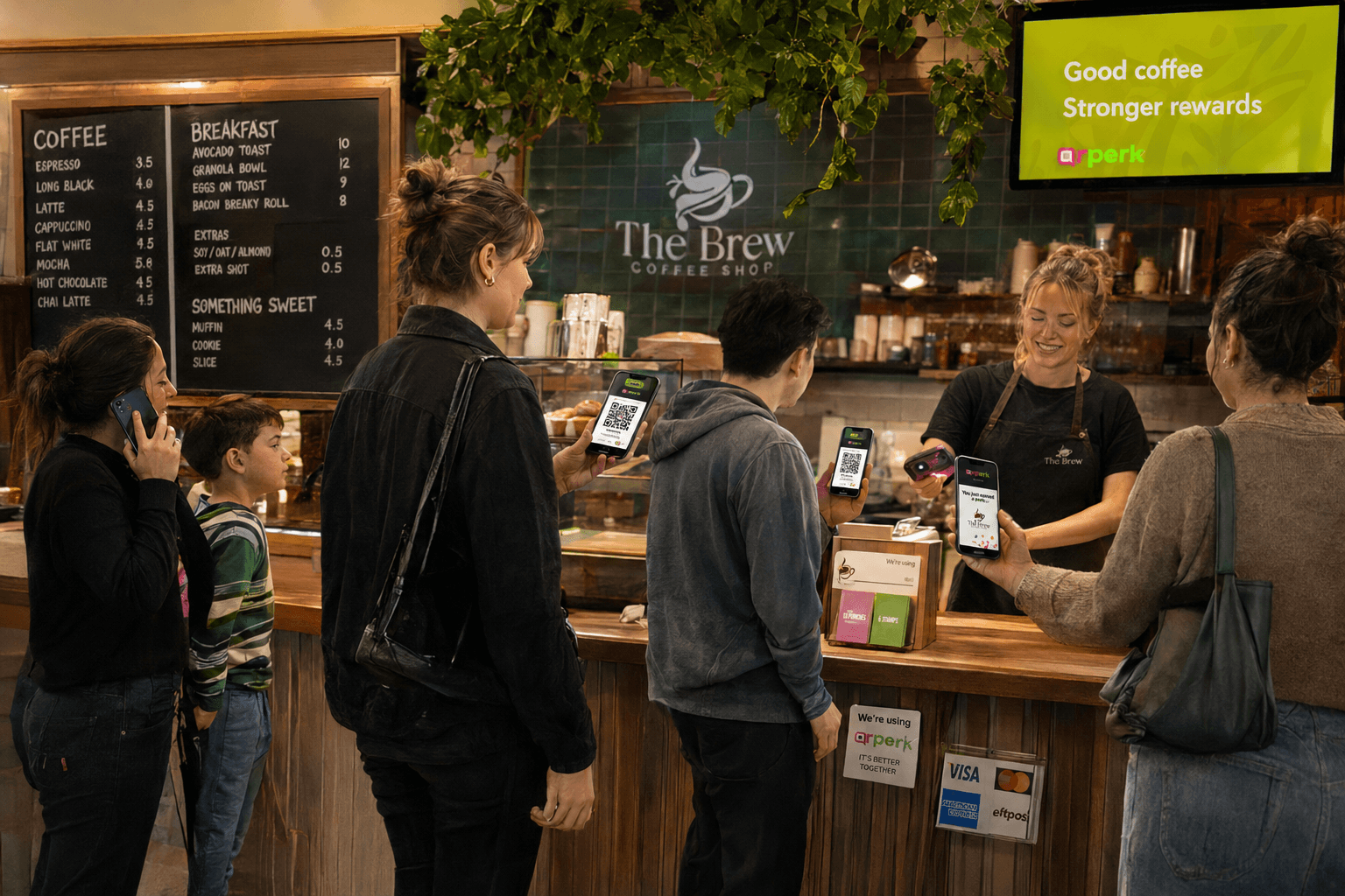 Customers in a café queue showing QrPerk codes at the register